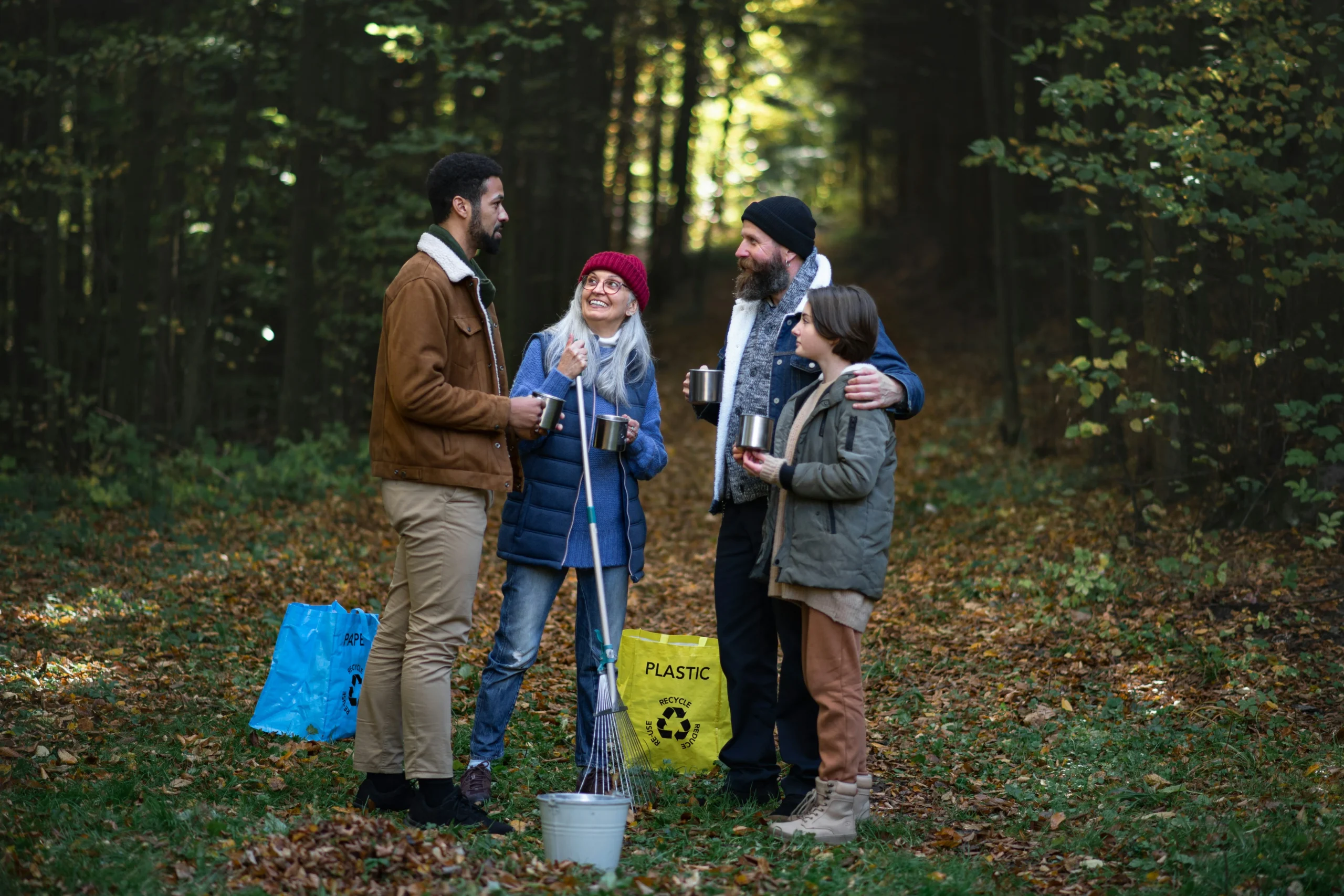 Four people dressed casually while standing outside preparing to clean up the outdoors, demonstrating what inspirational brands do.